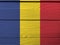 Flag of Romania on wooden wall background. Grunge Romanian flag texture.