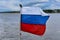 The flag of Russia flies in the wind against the background of the seascape