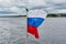 The flag of Russia flies in the wind against the background of the seascape