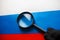 The flag of the Russian Federation is viewed through a magnifying glass. Spying and monitoring Russia. Monitoring the status of