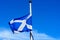 Flag of Scotland Saltire or the Saint Andrew`s Cross blowing in the wind towards clear blue sky in a sunny day