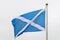 Flag of Scotland Saltire or the Saint Andrew`s Cross blowing in the wind towards cloudy grey sky in a rainy day