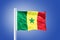 Flag of Senegal flying against a blue sky