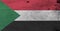 Flag of Sudan on wooden plate background. Grunge Sudan flag texture.