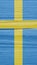 The flag of Sweden on a dry wooden surface, cracked with age. It seems to flutter in the wind. Mobile phone wallpaper. Vertical