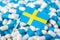 Flag of Sweden on piles of pills