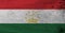 Flag of Tajikistan on wooden plate background. Grunge Tajik flag texture.