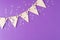 Flag triangular decorativ, party garland over colorful purple background. Christmas party, birthday mockup with copy space