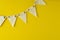 Flag triangular decorativ, party garland over colorful yellow background. Christmas party, birthday mockup with copy space