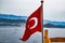 The flag of Turkey flutters in the wind on the deck of pleasure yacht