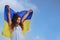 flag of Ukraine in hands of happy girl Ukrainian. child smiles wearing Ukrainian flag blue and yellow flag of Ukraine.