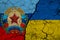 Flag of Ukraine and Lugansk People`s Republic on textured cracked earth