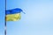 flag of Ukraine with a trident against the blue sky develops in the wind