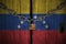 Flag of Venezuela painted on old and cracked wooden door, which is closed by an old chain and a padlock. Concept of the economic s