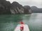 flag of Vietnam, red flag with a gold star, fluttering on ship in the Halong Bay at the Gulf of Tonkin of the South China Sea,