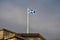 A flagpole with a Scottish flag on display on the roof of a historic building in the city center of Glasgow.