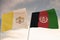 Flags of Afghanistan and Vatican waving with cloudy blue sky background, 3D rendering