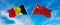 flags of China and Belgium waving in the wind on flagpoles against sky with clouds on sunny day. Symbolizing relationship, dialog