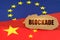 On the flags of China and the European Union lies a cardboard plate with the inscription - Blockade