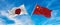 flags of China and japan waving in the wind on flagpoles against sky with clouds on sunny day. Symbolizing relationship, dialog
