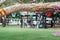 Flags of different countries in the tree branch with blured people in park doing barbecue together. Multicultural