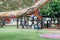 Flags of different countries in the tree branch with blured people in park doing barbecue together. Multicultural