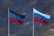 Flags of the Donetsk and Lugansk People's Republics against a dark cloudy sky.