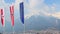 Flags with EU, Austria, Tyrol emblems waving in air, mountains