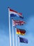 Flags of France, United Kingdom, Germany and European Union on flagpoles. Flag of France is on top.