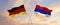 flags of Germany and Republic Srpska waving in the wind on flagpoles against sky with clouds on sunny day. Symbolizing