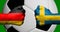 Flags of Germany and Sweden painted on two clenched fists facing each other with closeup 3d soccer ball in the background/Soccer m