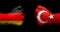 Flags of Germany and Turkey painted on two clenched fists facing