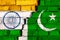 Flags of India and Pakistan on the brick wall with big crack in the middle. Symbol of problems between countries