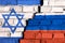 Flags of Israel and Russia on the brick wall with big crack in the middle. Symbol of problems between countries