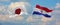 flags of Japan and Paraguay waving in the wind on flagpoles against sky with clouds on sunny day. Symbolizing relationship, dialog