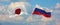flags of Japan and Russia waving in the wind on flagpoles against sky with clouds on sunny day. Symbolizing relationship, dialog