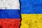 Flags of Russia and Ukraine painted on cracked wall background/Russia - Ukraine conflict concept