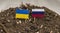 flags of Russia and Ukraine on toothpicks stuck in the dirty ground