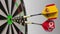 Flags of Spain and North Korea on darts hitting bullseye of the target. International cooperation or competition
