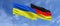 Flags of Ukraine and Germany on flagpoles in center. Flags on sky background. Place for text. Ukrainian. German. 3d illustration