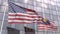 Flags of the United States and Malaysia in front of a modern skyscraper facade. 3D rendering