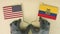 Flags of the USA and Ecuador made of recycled paper on the cardboard table