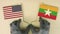 Flags of the USA and Myanmar made of recycled paper on the cardboard table