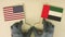 Flags of the USA and the UAE made of recycled paper on the cardboard table