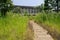 Flagstone path in weeds before Chinese grey brick building