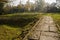 Flagstone paved path in hillside grass of sunny winter morning