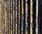 Flaking paint on rusty metal fence, perspective view