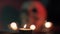 Flame of a burning candle against the background of a blurred skull