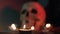 Flame of a burning candle against the background of a blurred skull