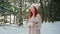 Flame candles, pretty girl with red hair holding a burning candle in hands, warming fire in winter forest